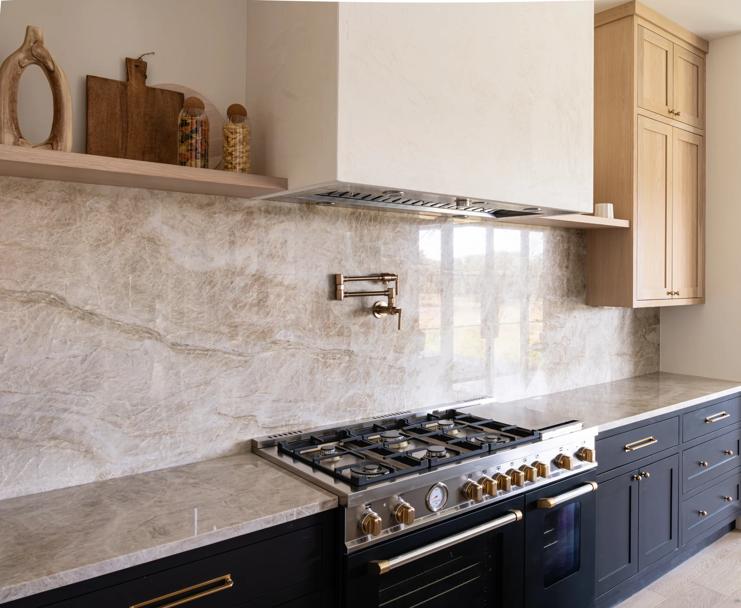 Elegant quartzite kitchen in Houston with a stylish stove, modern cabinetry, and a beautiful stone backsplash creating a sophisticated atmosphere