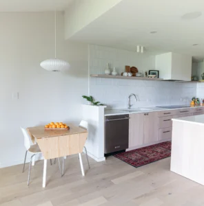 Minimalist quartz kitchen in Houston with natural stone countertops, light cabinetry, and a cozy dining area